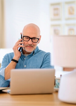 man looking at laptop while on the phone