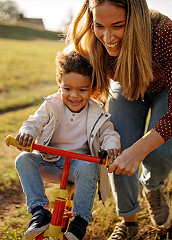 Woman helping young kid on a bike