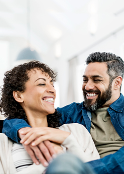 Two people smiling with their arms around each other