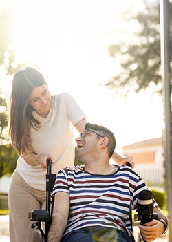 Woman pushing man in wheelchair
