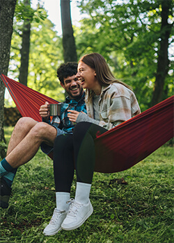 a man and women sitting together on a hammock