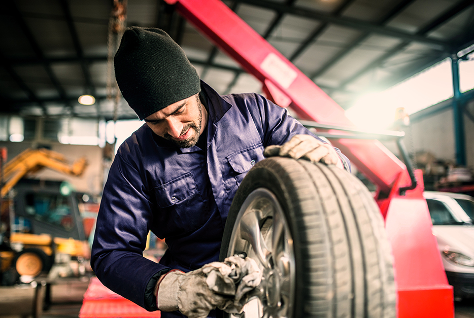 Mechanic putting on a car tire