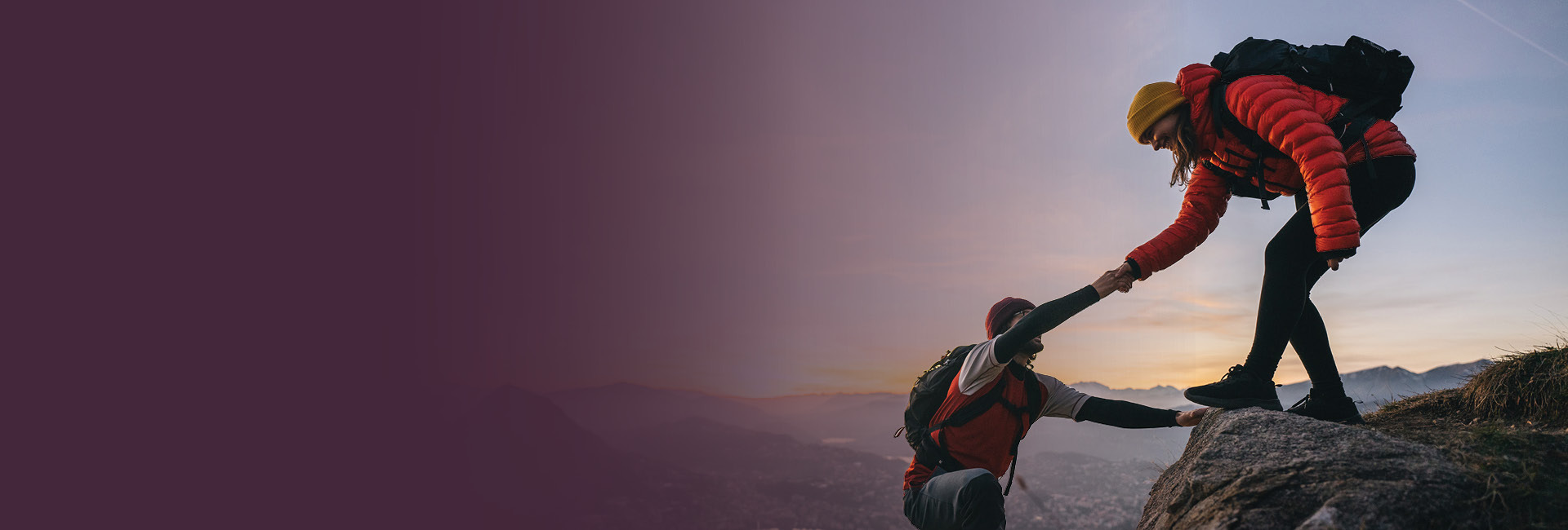 Hikers helping each other up a hill