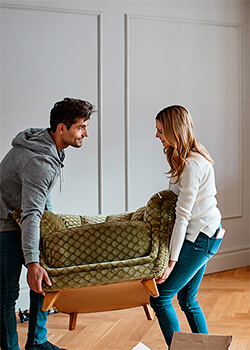 A man and women carrying a couch