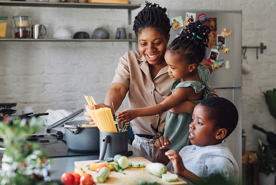 Mother cooking with her two kids