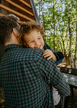 Man holding his child outside the family cottage