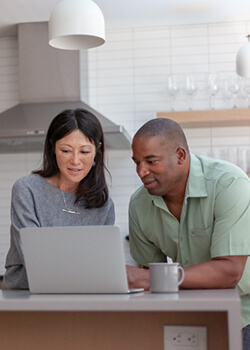 A woman and a man looking at a laptop