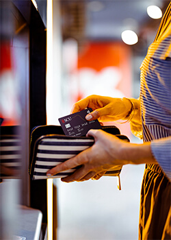 A woman holding a wallet with an SCU debit card