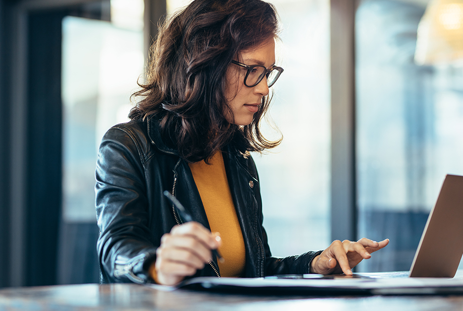 Women at a computer taking notes