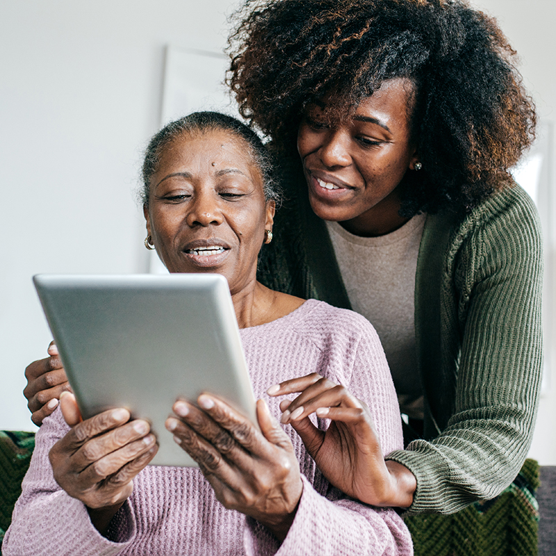 Daughter helping her mom use her tablet