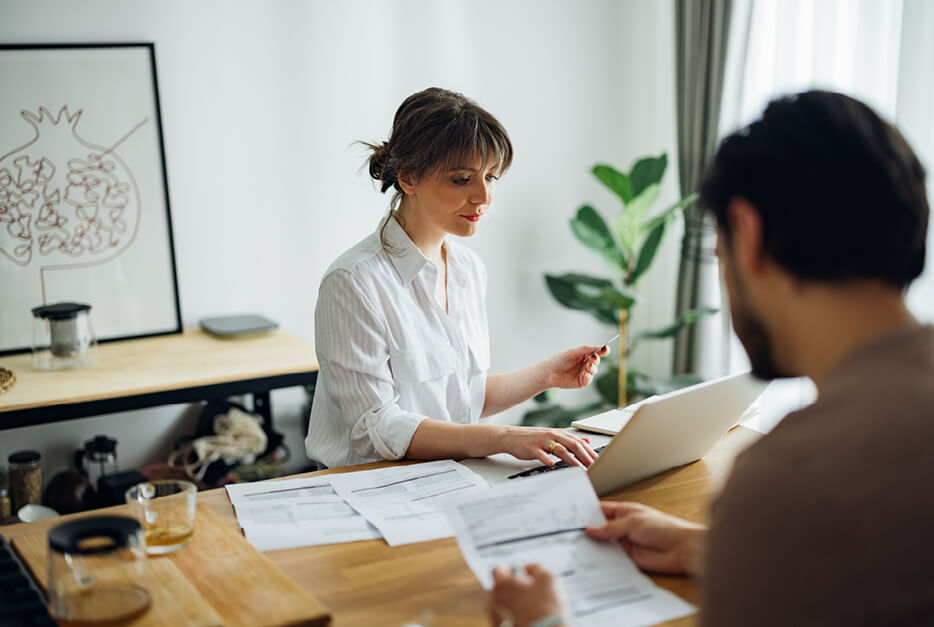 Couple sitting at computer going through bills