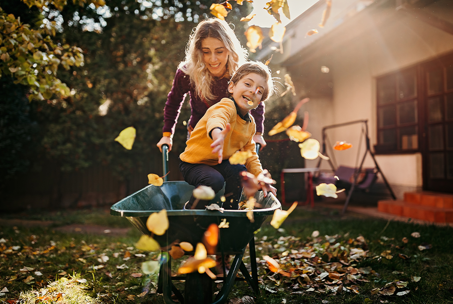 Mom pushing her son in a wheelbarrow