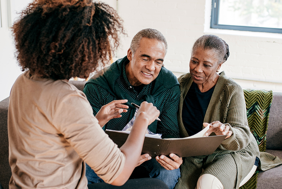 Couple sitting down and talking with a wealth advisor