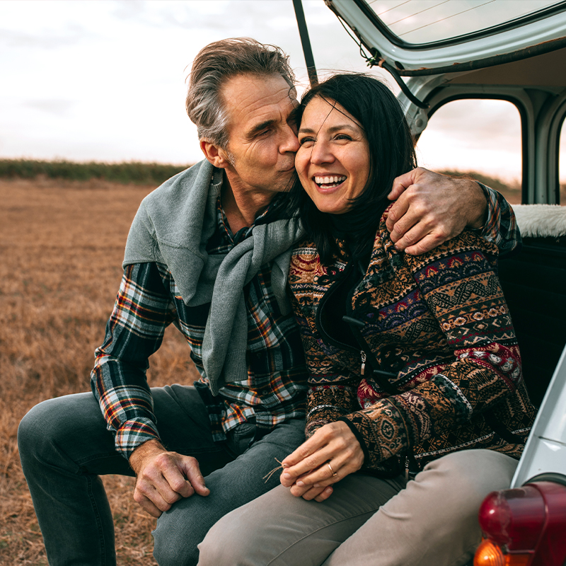 Couple sitting together in the back of their vehicle