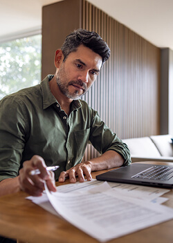 A man looking at documents on his desk