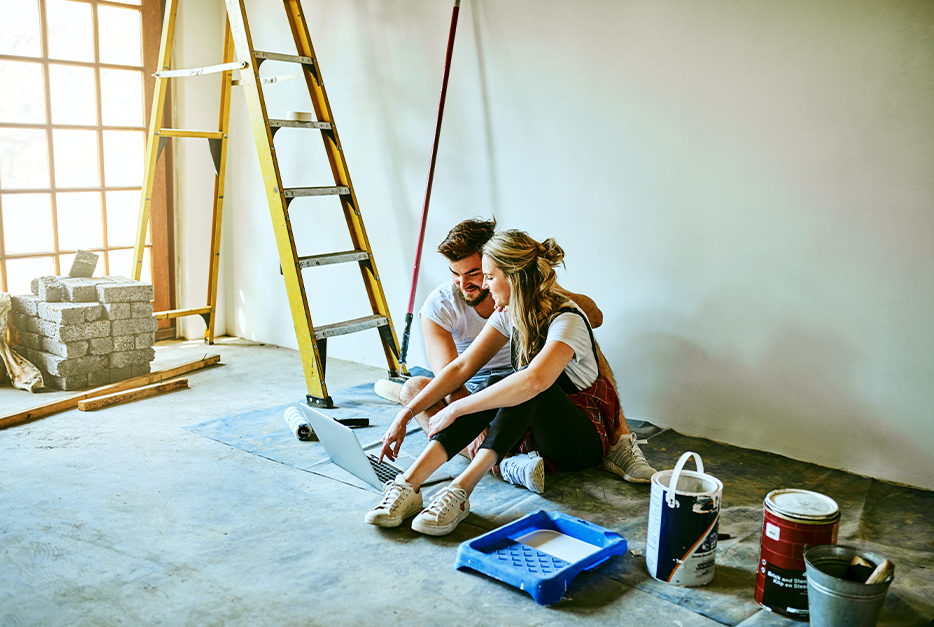Couple taking a break from painting their house