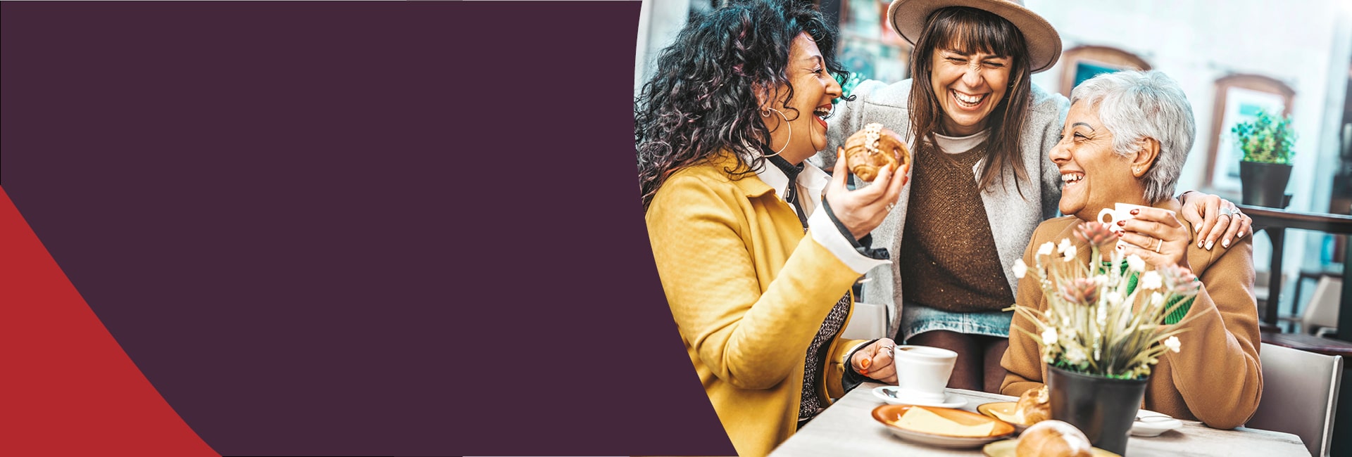 Three middle aged women laughing at a cafe