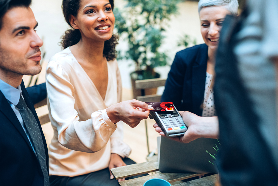 Woman using SCU credit card on a hand-held terminal