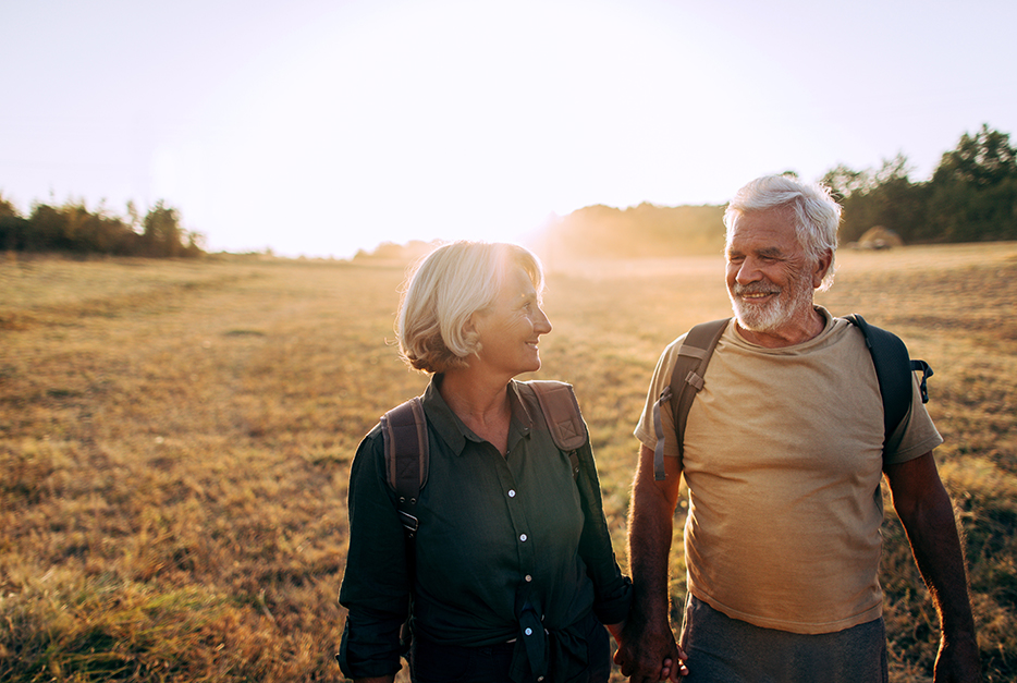 Couple standing a field holding hands