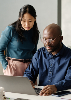 A man and a woman looking at a laptop screen