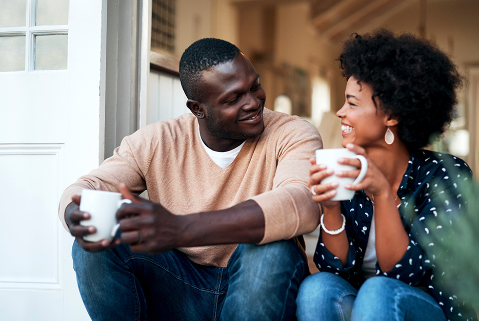 Couple sitting on the porch drinking coffee together