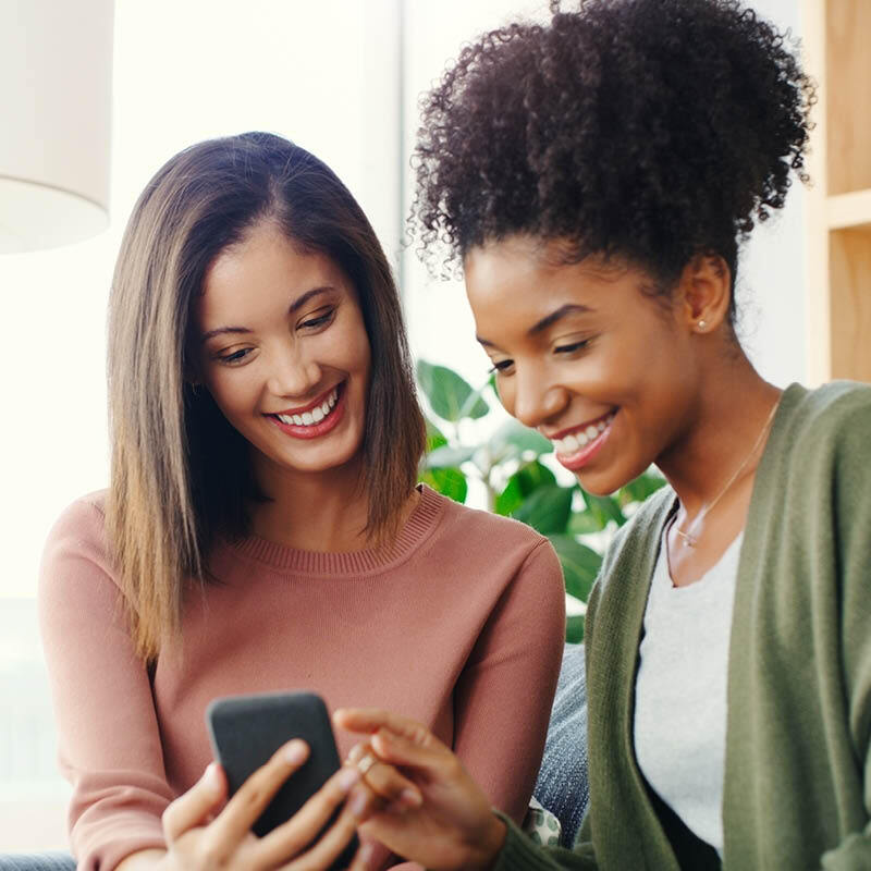 friends smiling and looking at phone