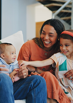 A woman and two children sitting together and smiling