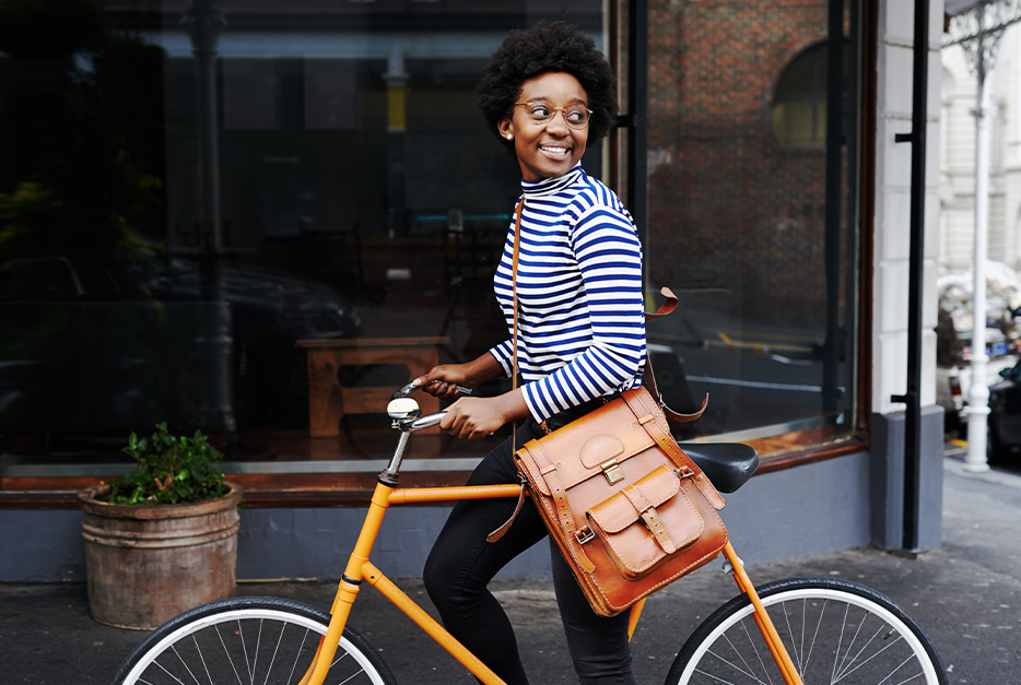 Woman walking her bike down the street