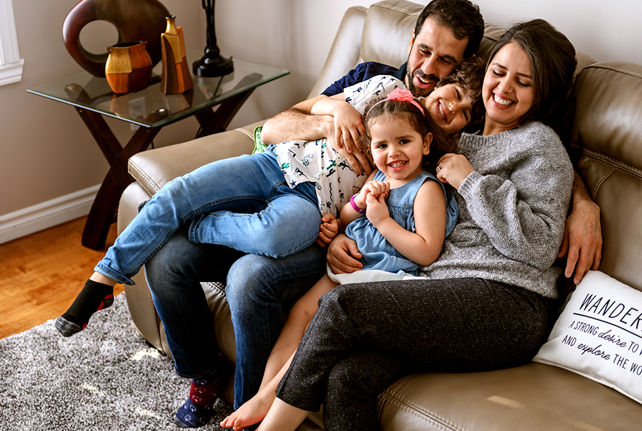 Family sitting on the couch cuddling