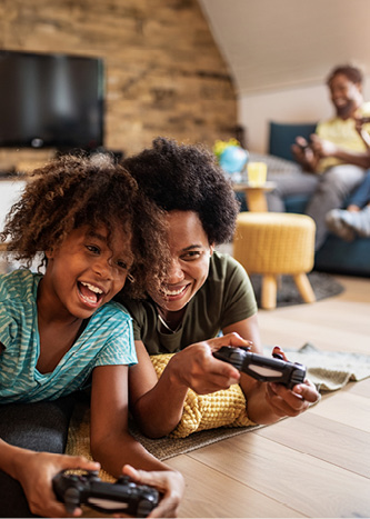 Two kids playing a video game on the floor