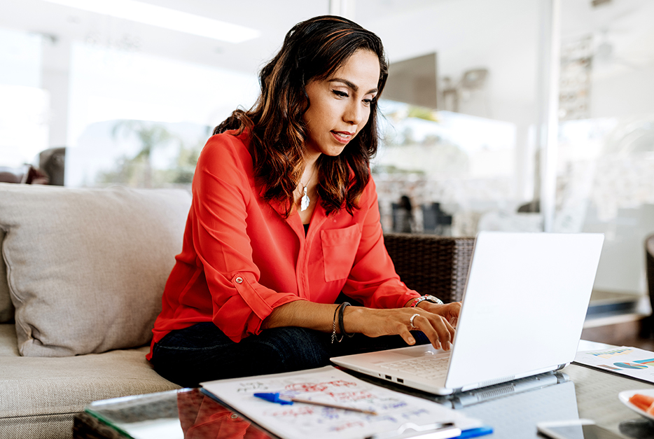 Woman sitting on her couch with her laptop