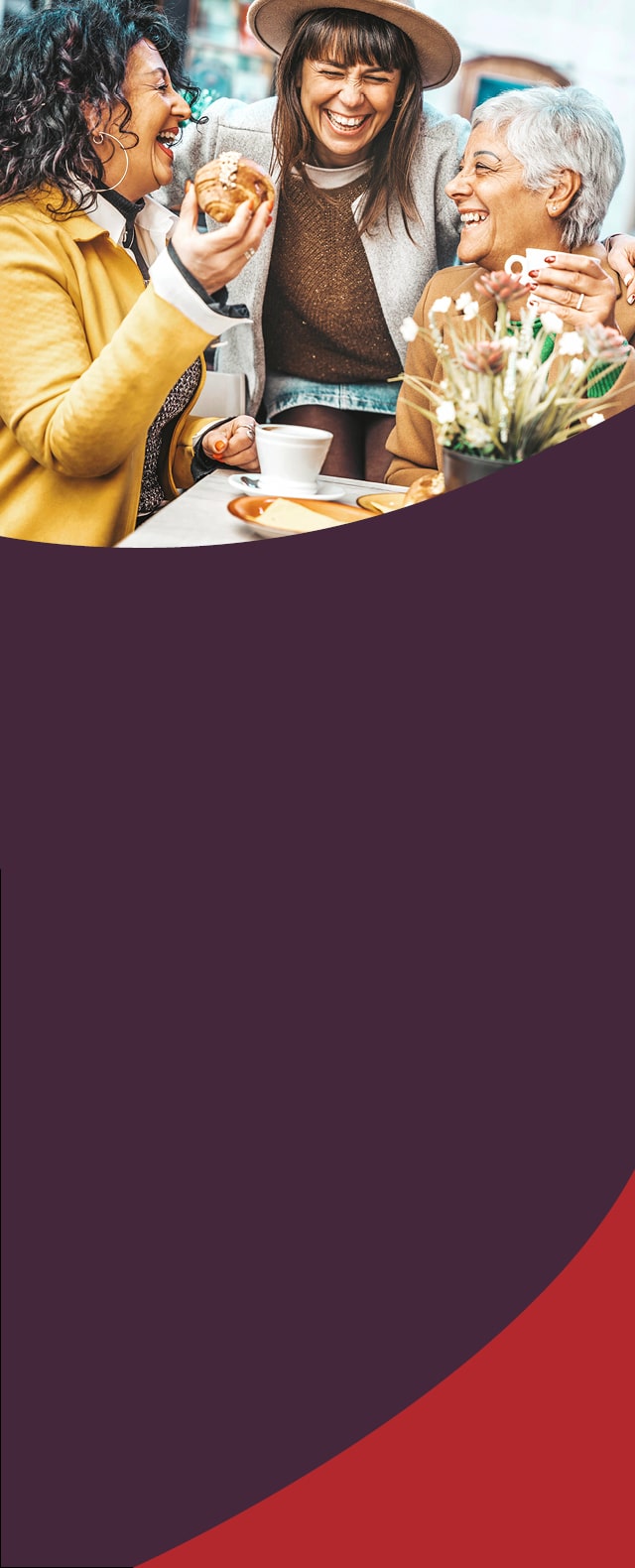 Three middle aged women laughing at a cafe