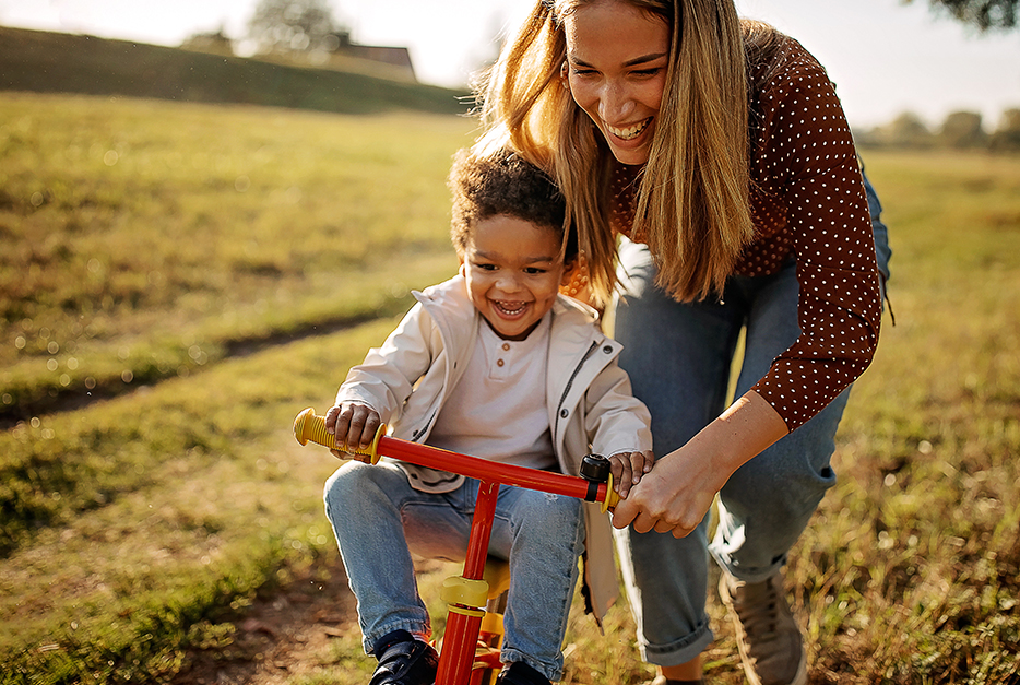 Mom helping her son learn to ride a bike