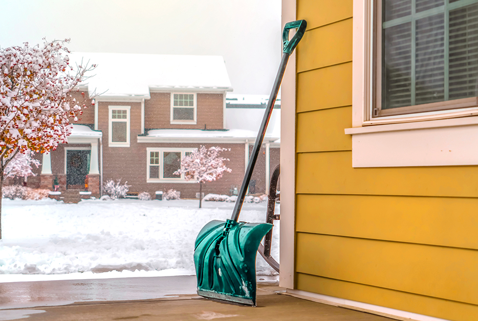 Snow shovel leaning against a house