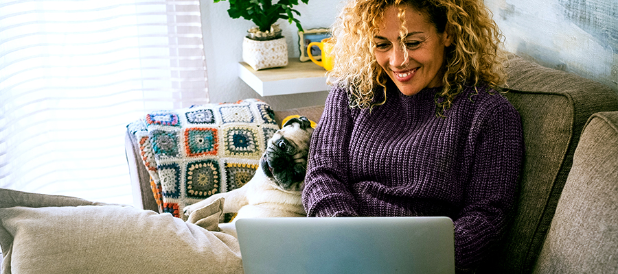 Woman smiling as she sits with her laptop