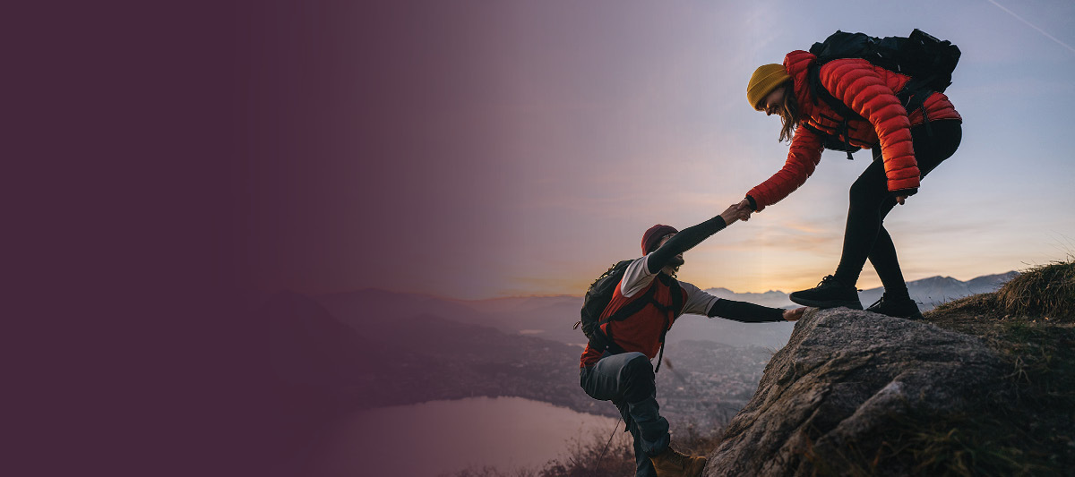 hikers helping each other up a hil