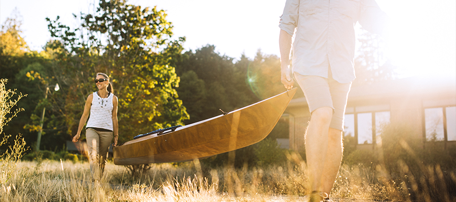 Couple carrying canoe together