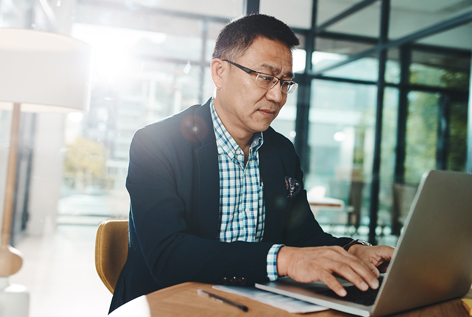 Man sitting at his desk with his laptop